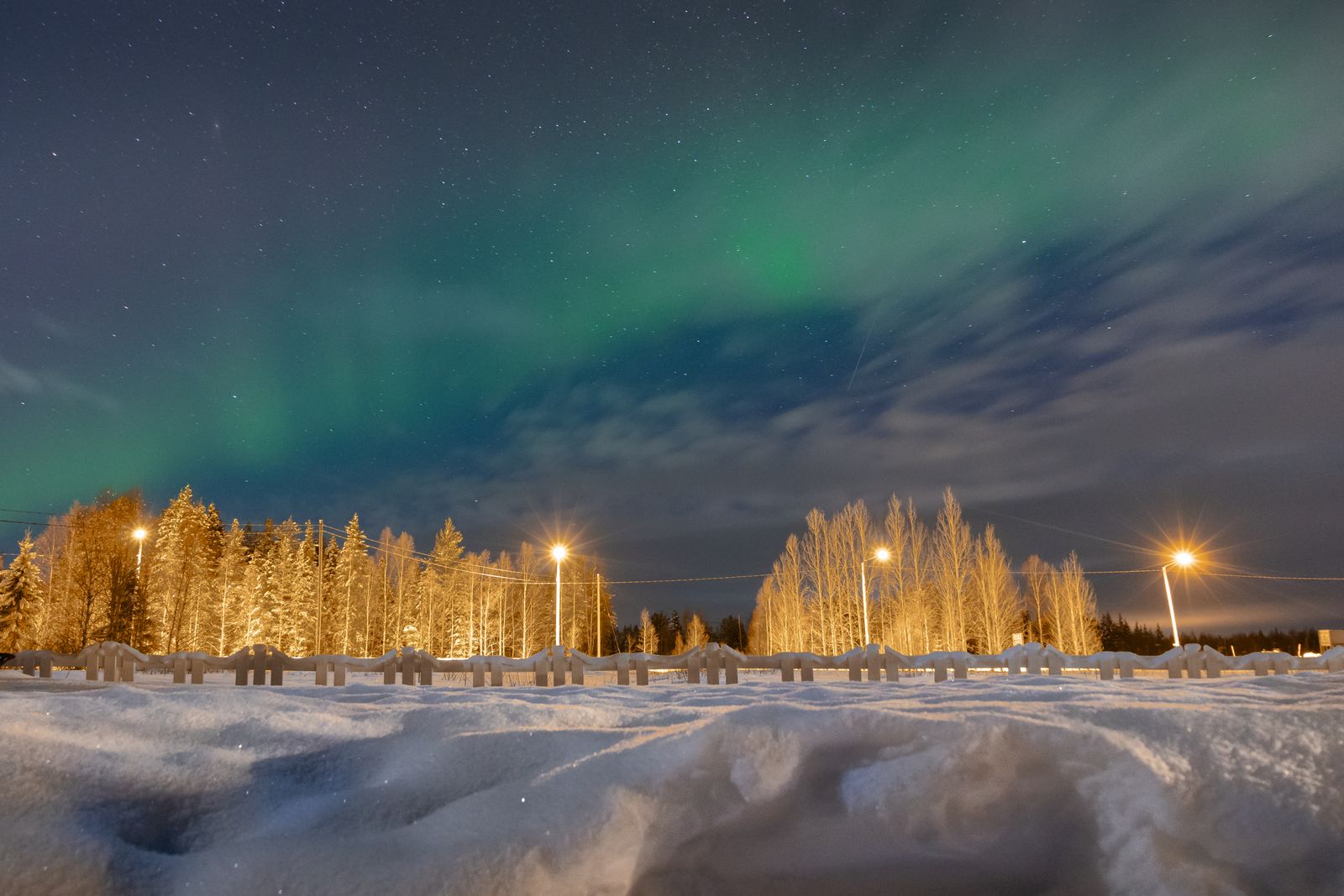 Northern lights over a snowy Lapland landscape near Rovaniemi, Finland